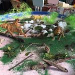 Animals in green glitter and leaves and sticks for exploration
